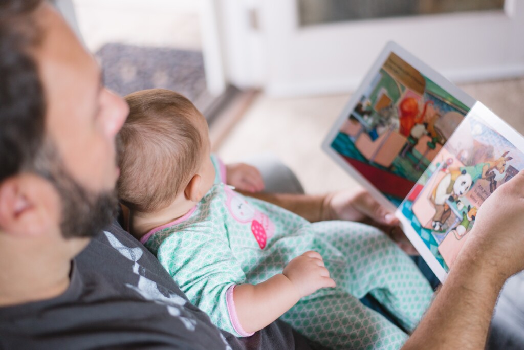 baby and adult sharing a book